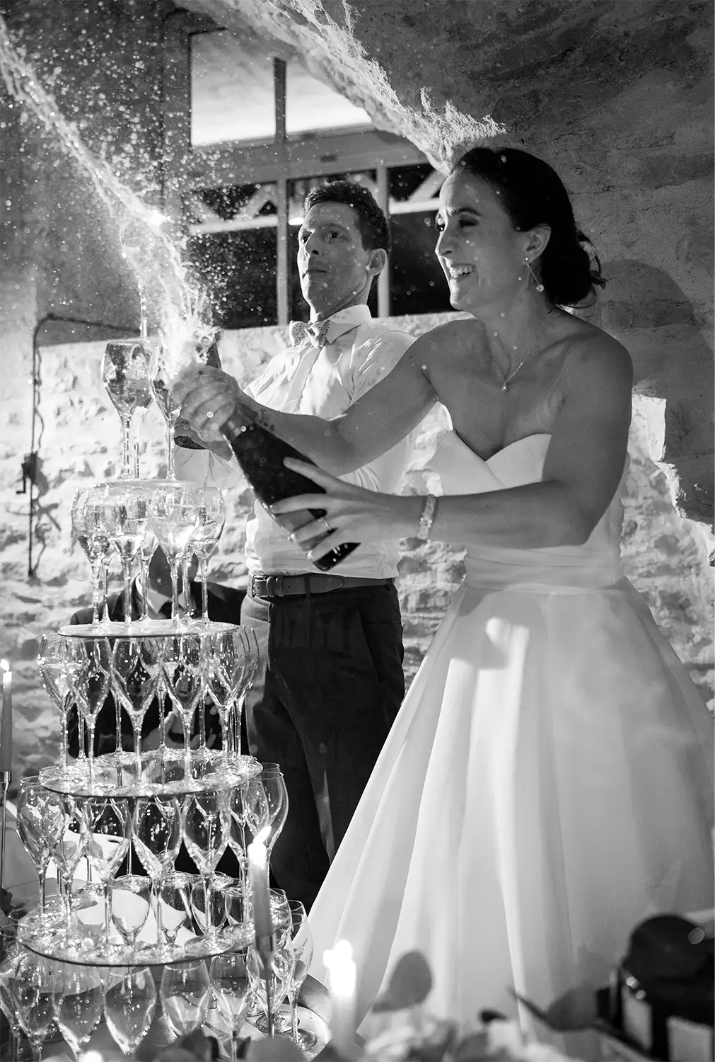 Les mariés ouvrent une bouteille de champagne au Château Champ-Renard
