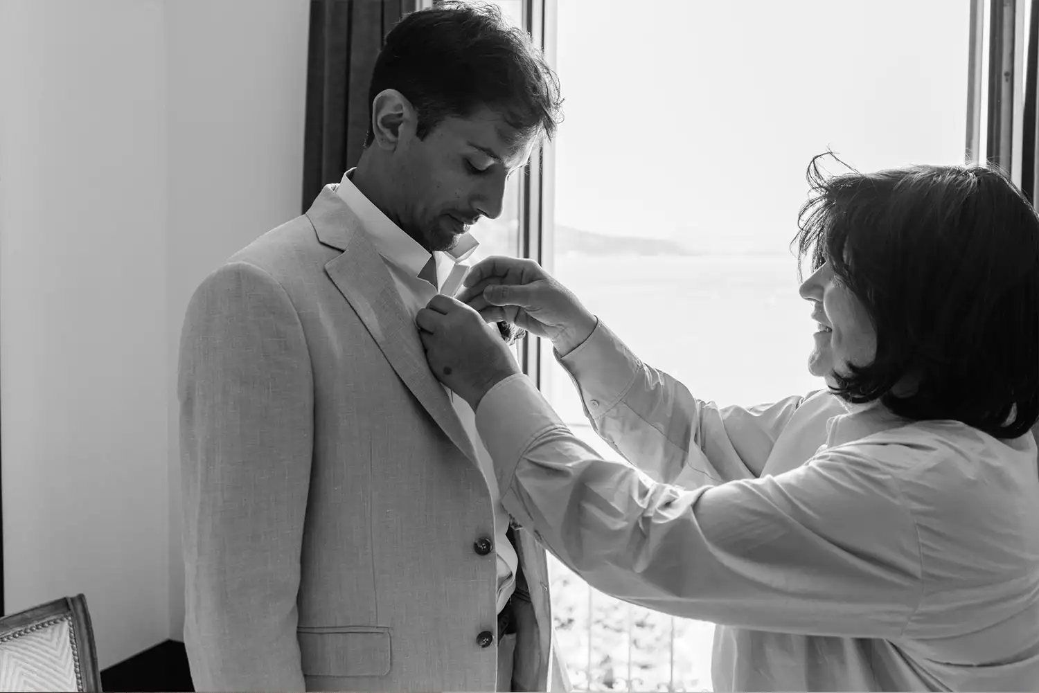 La maman du marié l'aide pour mettre sa cravate au Palace de Menthon à Annecy