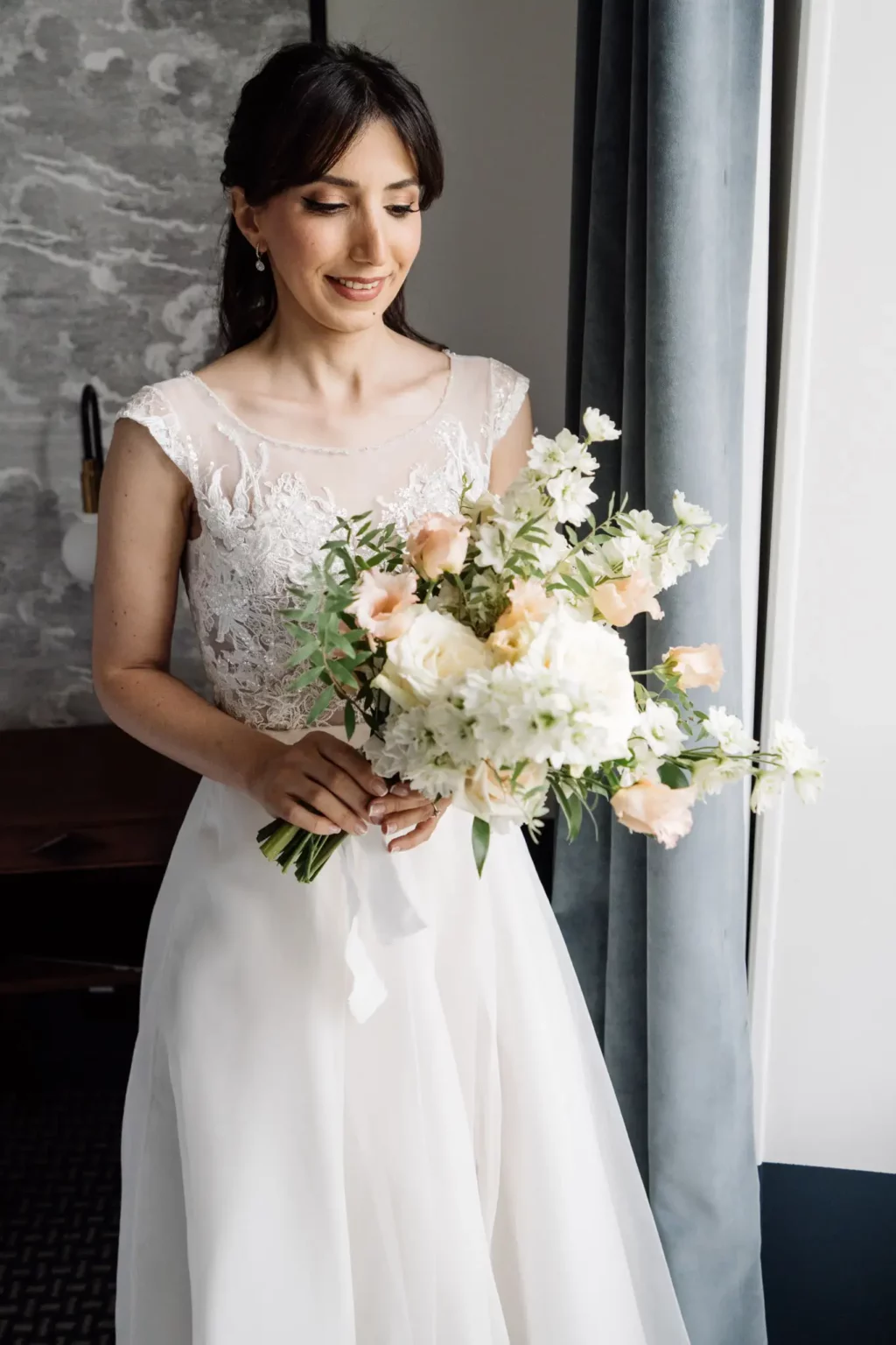 La mariée avec son bouquet de fleurs juste après des préparatifs au Palace de Menthon